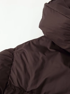 Detail of dark brown padded jacket showing smooth nylon fabric and stitching quality