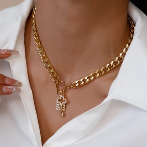 Detail of gold chain necklace with sparkling crystal key pendant and OT toggle clasp
