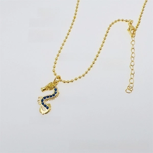 Detail view of dragon pendant with deep blue zircon stones and gold bead chain