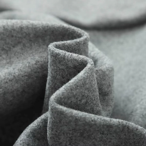 Close-up of thick dark grey wool fabric texture with natural soft folds and fine fibers