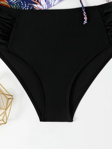 Detail view of high waisted black bikini bottom with slimming ruched sides and floral print