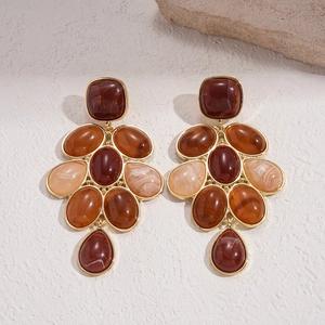Retro geometric resin earrings with gold frame and amber stones on textured stone