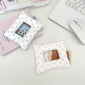 Detail of plush star-printed card holders with clear window on a desk setup