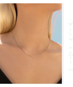 Close-up of a minimalist S925 sterling silver thin chain necklace on a model neck