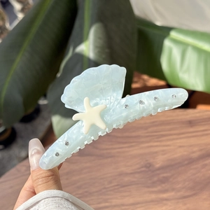 Pince à cheveux bleue avec texture de coquillage, étoile de mer crème et strass brillants