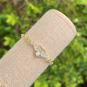 18K gold plated heart wing bracelet with central pearl and infinity link on display
