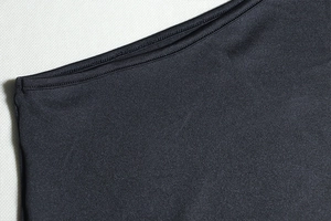 Detailed view of precise stitching and elastic fabric texture on a black bodycon dress