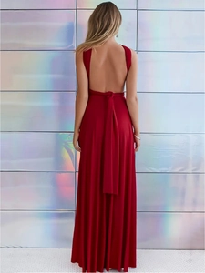 Detalle de vestido largo rojo con espalda descubierta y lazos cruzados en una modelo