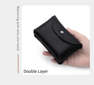 Detailed view of a black genuine leather coin purse held in one hand showing double layers