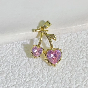 Macro shot of 18K gold cherry pendant with pink heart-shaped stones and green leaves