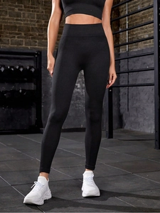 Detail showing the seamless knitting texture and high waistband of black yoga pants