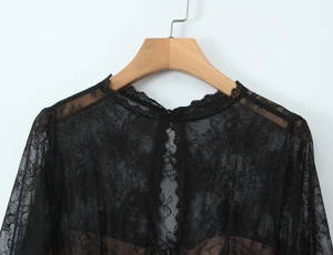 Close-up of black floral lace top showing sheer texture and delicate neckline details