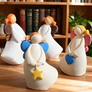 Lot de quatre figurines d'ange en résine avec cœurs et étoiles sur bureau en bois