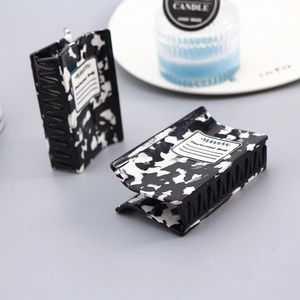 Detail of cow pattern acetate hair claws featuring a composition book design style