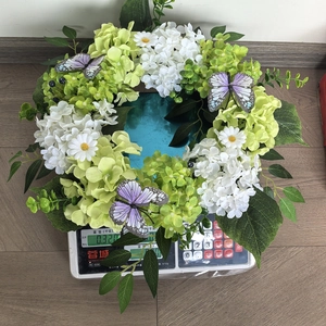 Detailed view of fall hydrangea wreath with butterflies being weighed on a scale
