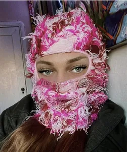 Close-up of pink and red fuzzy knit balaclava with eye openings for winter