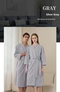 Close-up of silver-gray waffle weave bathrobe with white piping and textured fabric detail