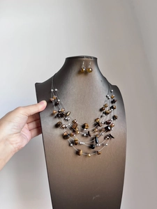 Detailed view of the layered brown tiger eye beaded necklace and matching earrings set