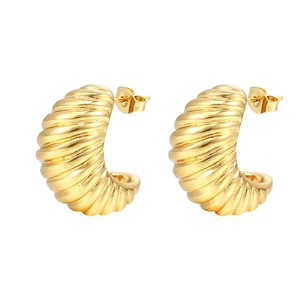 Detail of gold twisted croissant hoop earrings with a high-shine metallic finish