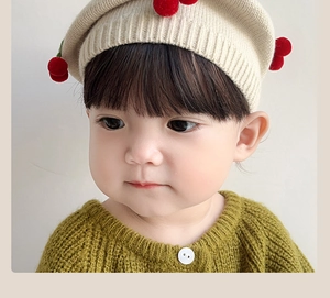 Detailed knit texture of baby cherry beret and green cardigan for autumn winter