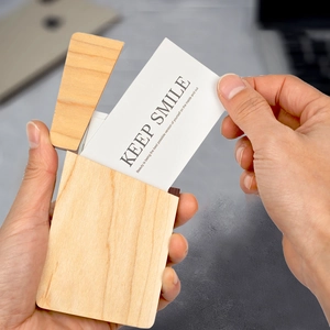 Handheld view of a premium black walnut wood business card holder with custom engraving