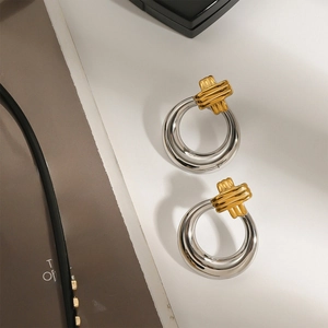 Minimalist 18k gold and silver two-tone ribbed metal hoop earrings on fashion magazine