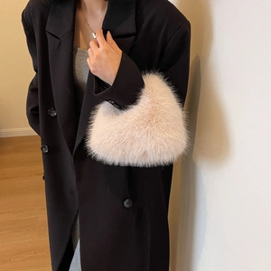 Furry light pink plush handbag for women shown with a dark coat in an autumn winter style