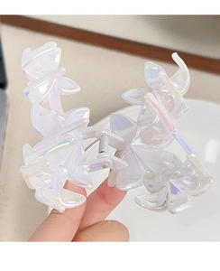 Close-up of holographic white acrylic flower hair claw clip with gradient rainbow luster
