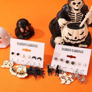 Detailed view of Halloween earring sets with spiders and ghosts on orange festive backdrop