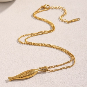 Détail du pendentif poisson en acier plaqué or 18K sur une fine chaîne gourmette