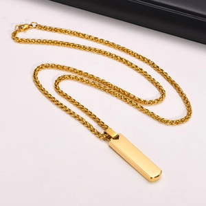 Detail of a polished gold stainless steel vertical bar pendant on a braided chain