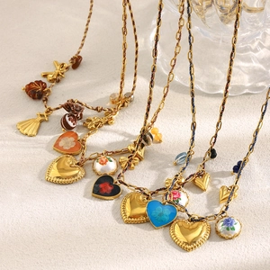 Gros plan de colliers trombone dorés 18K avec pendentifs cœurs en résine à fleurs colorées