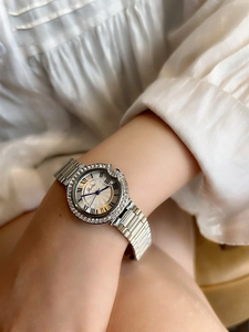 Elegant ladies' silver watch with diamond bezel worn on wrist for a stylish look