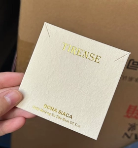 Detail shot of textured cream jewelry display card with custom brand logo and typography