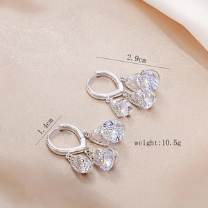 Detail showing 2.9cm silver drop earrings with clear round gems on champagne silk