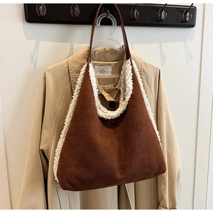 Detailed view of brown plush tote bag with white fur trim hanging on a beige coat