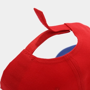 Macro detail of red baseball cap showing Velcro adjustable strap and stitching
