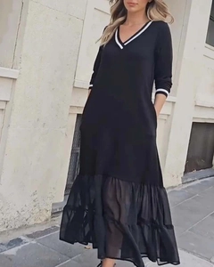 Détail du col en V avec bordure blanche et ourlet en tulle plissé sur cette robe noire