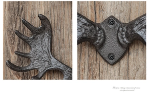 Close-up of vintage cast iron antler wall hook with rustic finish and screw holes