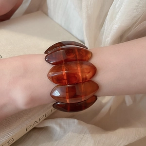 Close-up of amber resin stretch bracelet with oval segments on a model's wrist