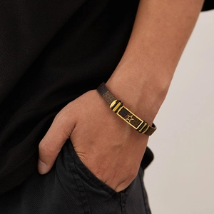 Close-up of retro punk leather bracelet with gold star plate on a male wrist
