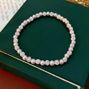 Detail of pink pearl bracelet with sparkling diamond-encrusted silver beads on leather
