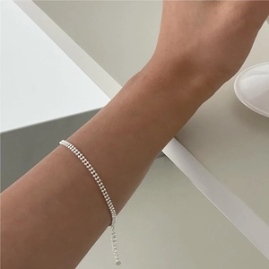 Detail of adjustable S925 sterling silver beaded bracelet on wrist for a minimalist style