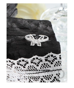 Close-up of S925 sterling silver butterfly ring with texture on charcoal and lace