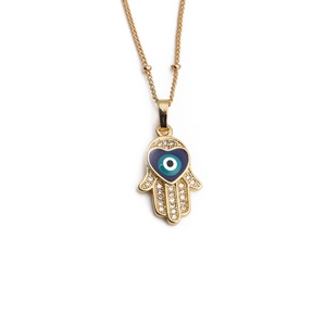 Gold Hamsa Hand necklace with blue evil eye and micro-pave zircons on white background