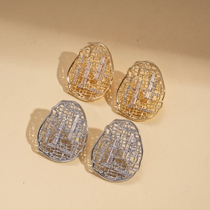 18k gold plated hollow oval stud earrings with cubic zirconia on textured background
