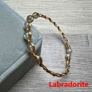 Detail of handmade labradorite and pearl wire wrapped bracelet on a velvet jewelry box