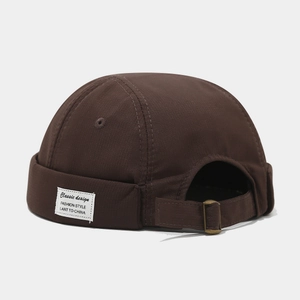 Vue détaillée du bonnet docker marron foncé avec boucle de réglage en cuivre vintage