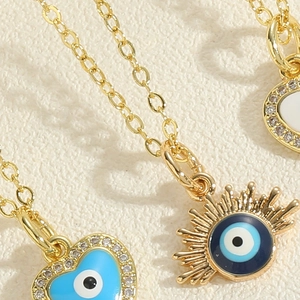 Detailed close-up of evil eye heart pendant with blue enamel and zircon stones
