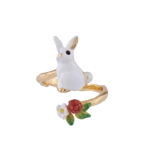 Macro detail of enamel white rabbit, red berry and flower on adjustable branch ring